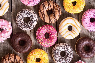 Çikolata kaplı, pembe jöleli ve serpiştirilmiş çeşitli çörekler. Üst görünüm