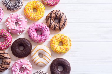 Çikolata kaplı, pembe jöleli ve serpiştirilmiş çeşitli çörekler. Üst görünüm