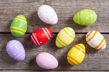 Ahşap zemin üzerinde renkli paskalya yumurtaları koleksiyonu