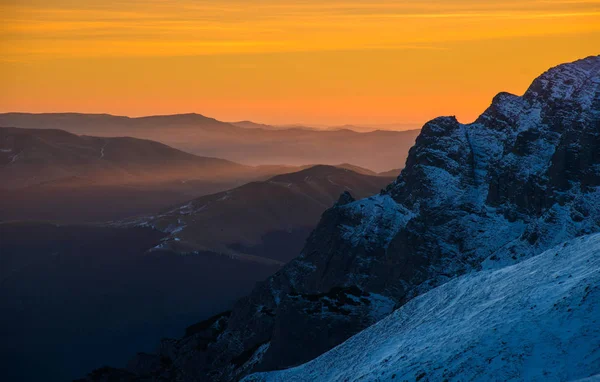 Orange sky and snow powdered mountain slope — Stock Photo, Image