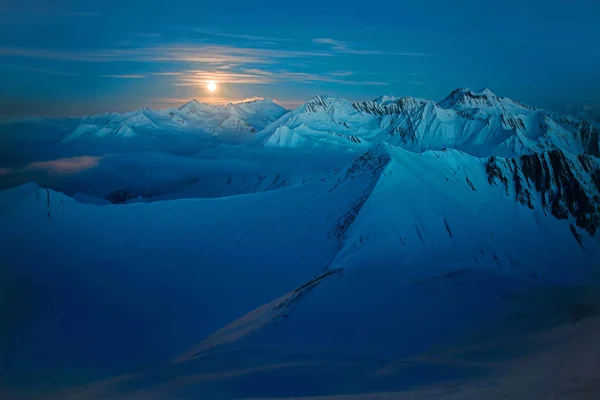 Lua iluminando montanhas nevadas — Fotografia de Stock