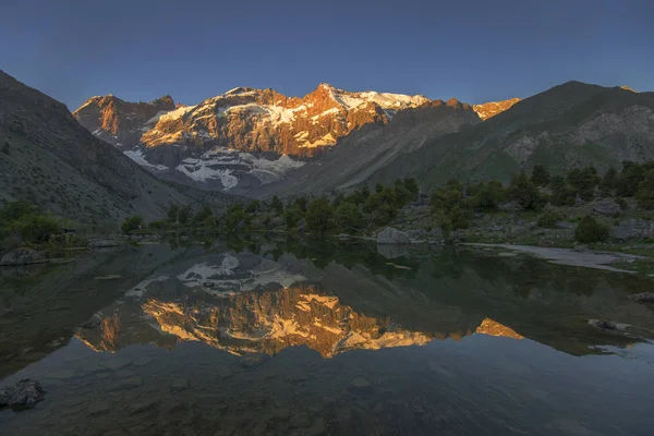Montanha iluminada pelo sol refletindo no lago — Fotografia de Stock