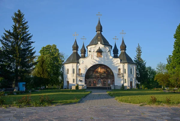 Kościół św. Jerzego w Plyashevie otoczony bujnym zielonym drzewem — Zdjęcie stockowe