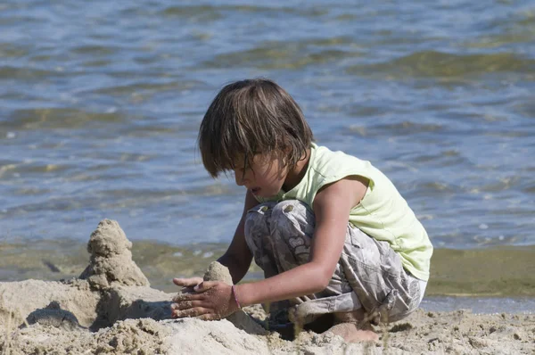 Flicka bygger sandslott på stranden — Stockfoto