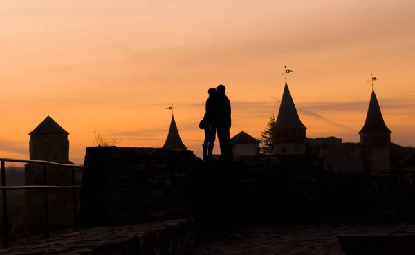 在城堡轮廓背景下亲吻夫妻 — 图库照片