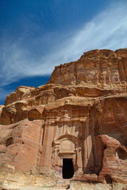 Petra. Kaya mezarına oyulmuş. Arka planda mavi gökyüzü.