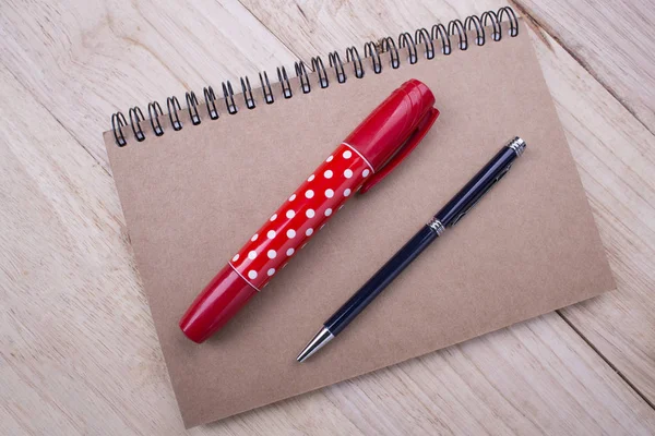 Book with red marker pens and black pen on wooden background — Stock Photo, Image
