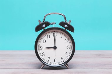 Tahta üzerinde yeşil arka planı olan bir Siyah Retro alarm saati