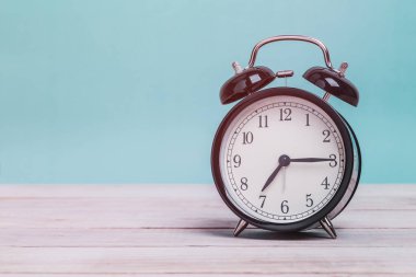 Tahta üzerinde yeşil arka planı olan bir Siyah Retro alarm saati