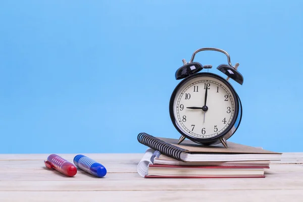 Ein Stapel Bücher und mit Buntstift und Wecker auf einem Holz — Stockfoto