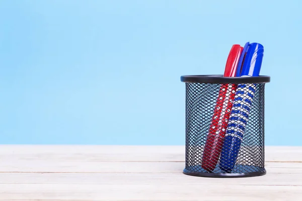 Fabricante de bolígrafos de colores en un soporte de madera con fondo azul —  Fotos de Stock