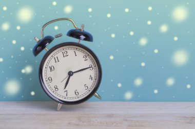 Tahta üzerinde yeşil arka planı olan bir Siyah Retro alarm saati