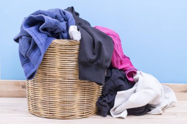 Çamaşır sepetindeki elbiseler odasındaki ahşap masada.