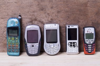 Ahşap arka planda izole edilmiş eski cep telefonu koleksiyonu