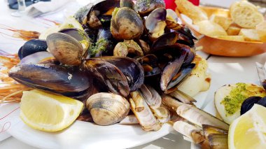 delicious dishes with baked mussels and shrimps with lemons and sauces