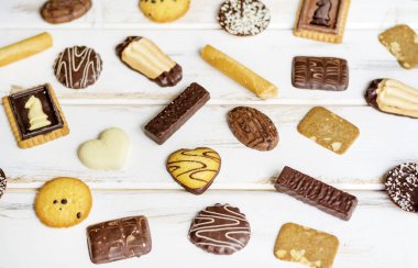 Beyaz ahşap masada bir sürü çikolatalı kurabiye.