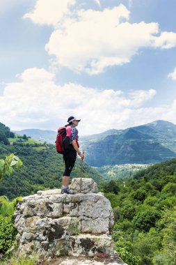 Yüksek dağdaki bir bankta oturan kadın.