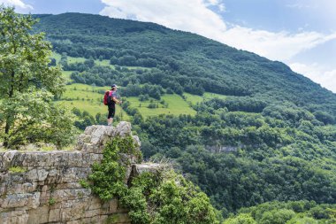 Yüksek dağdaki bir bankta oturan kadın.