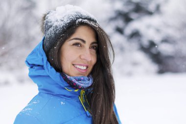 close up portrait of smiling young woman on winter park background