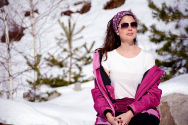 attractive woman in sunglasses posing on winter background