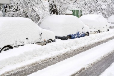 cars covered with snow on winter street background