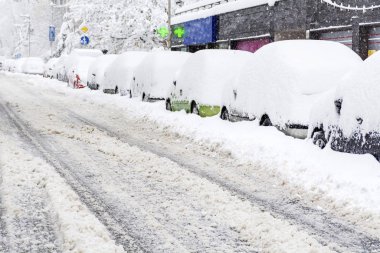 cars covered with snow on winter street background