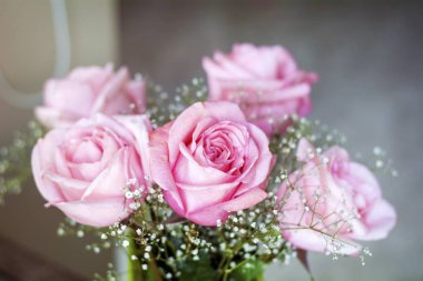 beautiful bouquet of pink roses on table background