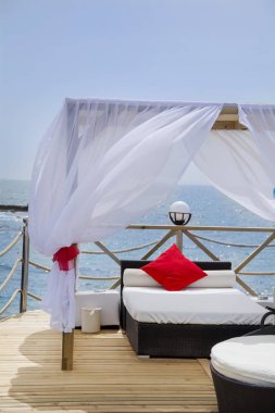 Türkiye 'de Deniz üzerindeki Ahşap İskeledeki Beyaz Perdeli Lüks Güneş Yatakları