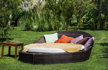 Yeşil egzotik bir bahçede muz ağaçlarıyla yastıklı güneşli yataklar 