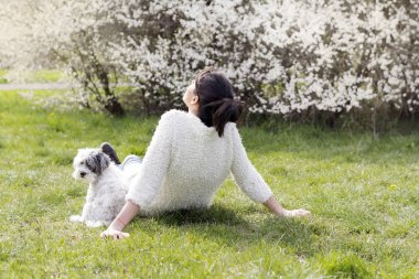 Güzel Gülümseyen Kadın Bir Bahar Bahçesi onu Sevimli Köpek Sarılma . İlkbaharda Evcil Hayvan ve Sahibi Açık
