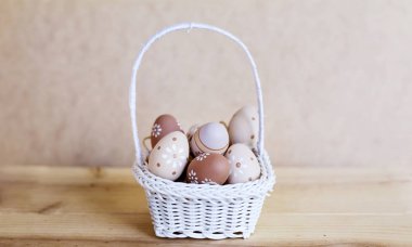 Küçük beyaz sepetteki bej Paskalya Yumurtaları 