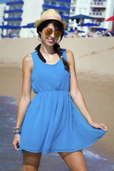 快乐的年轻女子与帽子和蓝色衣服在海滩享受夏日假期 — 图库照片