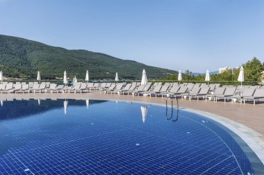 Denizin üstünde dağ manzaralı lüks bir havuz.