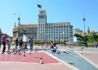 BARCELONA, İspanya, 22 Haziran 2016: Barcelona 'daki Placa de Catalunia Meydanı' nda Güvercinleri Besleyen Kadın