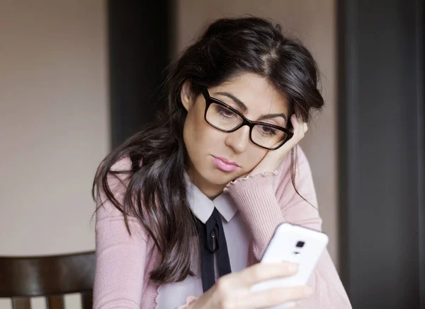 Mujer Joven Triste Mirando Smartphone Casa —  Fotos de Stock
