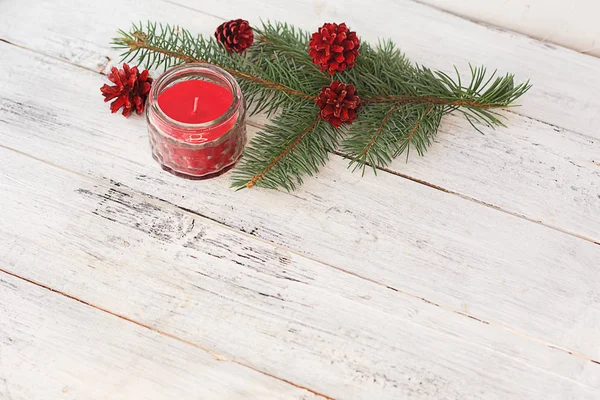 Composição de Natal. Ramos de abeto com cones vermelhos pintados e um — Fotografia de Stock