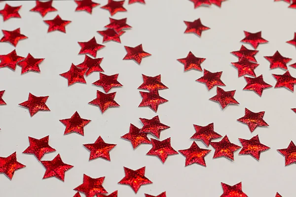 Röda glänsande stjärnor på en ljus bakgrund. Festlig sammansättning. — Stockfoto