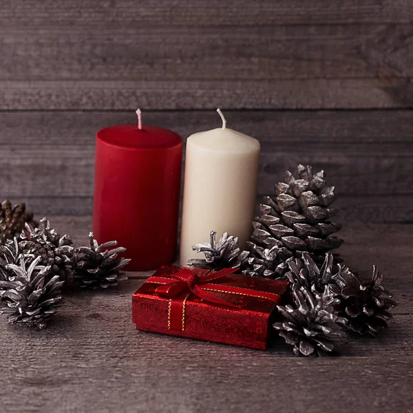 Composição de Natal com velas e cones em um quadrado de madeira — Fotografia de Stock