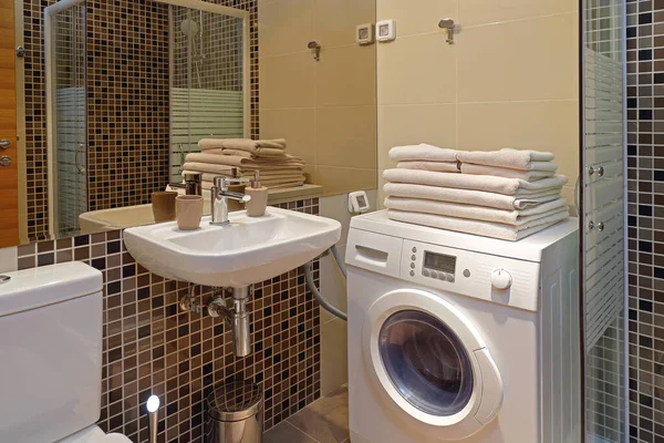 Çamaşır makinesi olan küçük bir banyonun içi.