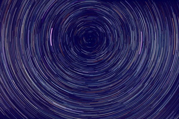Yıldız izleri. Dünya 'nın dönüşü nedeniyle gece gökyüzünde kutup yıldızlarının etrafında ışık çizgileri.