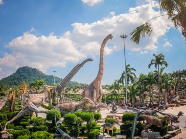 Pattaya, Tayland - 31 Aralık 2019: Suan Nongnooch Pattaya 'nın bahçe manzarası, Fransız bahçesi, mavi gökyüzü ve yeşil dağ ve dinozor heykeli.