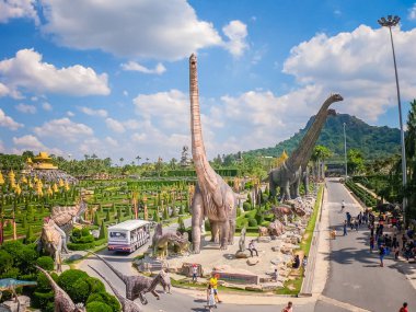 Pattaya, Tayland - 31 Aralık 2019: Suan Nongnooch Pattaya 'nın bahçe manzarası, Fransız bahçesi, mavi gökyüzü ve yeşil dağ ve dinozor heykeli.