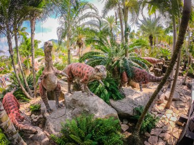 Pattaya, Tayland - 31 Aralık 2019: Suan Nongnooch Pattaya 'nın bahçe manzarası, Fransız bahçesi, mavi gökyüzü ve yeşil dağ ve dinozor heykeli.