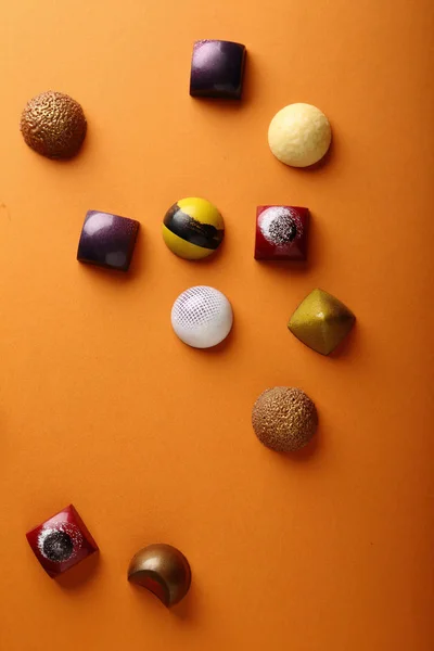 Assortiment van chocolade snoep op een oranje achtergrond — Stockfoto