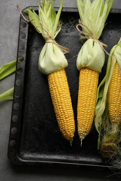 Three fresh corn cob above on baking tray — Stock Photo, Image