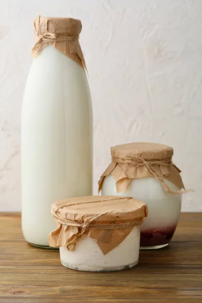 Milk in bottle and cream in jar — Stock Photo, Image