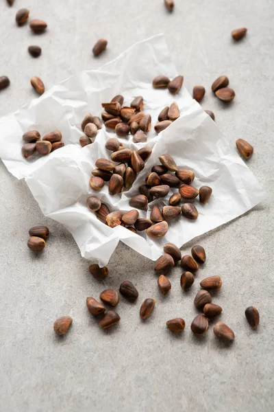 Organické borovicové ořechy na šedém pozadí — Stock fotografie