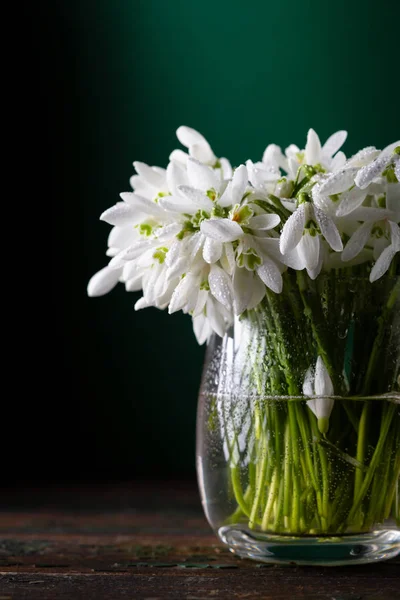 Flores de primavera en jarrón de vidrio sobre fondo rústico —  Fotos de Stock
