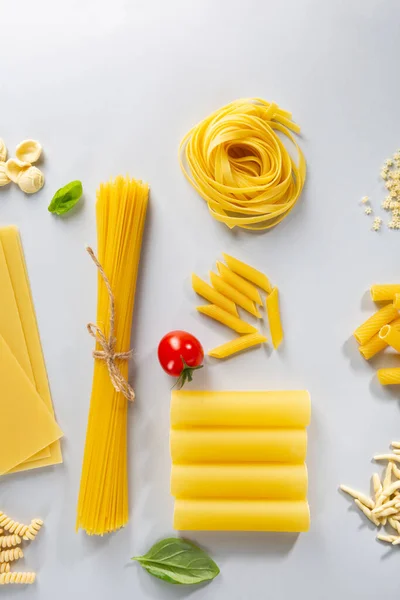 Obehandlad Pasta Och Tomater Ljus Bakgrund — Stockfoto