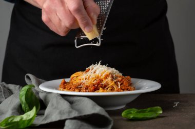 Bolonez makarnası. Makarnada elle rendelenmiş peynir.